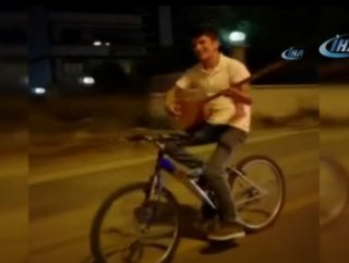 Bisikletin üstünde bağlama çaldı