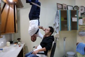 Müşterilerini tavandan sarkarak tıraş eden berber